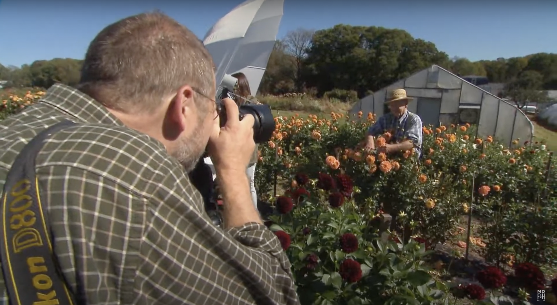 Photographer Edwin Remsberg takes a photo of a farmer in a field of flowers
