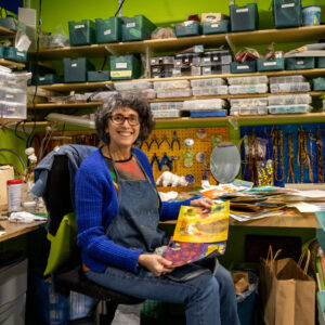 Artist Beth Schwartz holds pieces of painted paper in her studio in Baltimore, Md. on February 10, 2022. She creates these paintings to cut up and use in her collages.